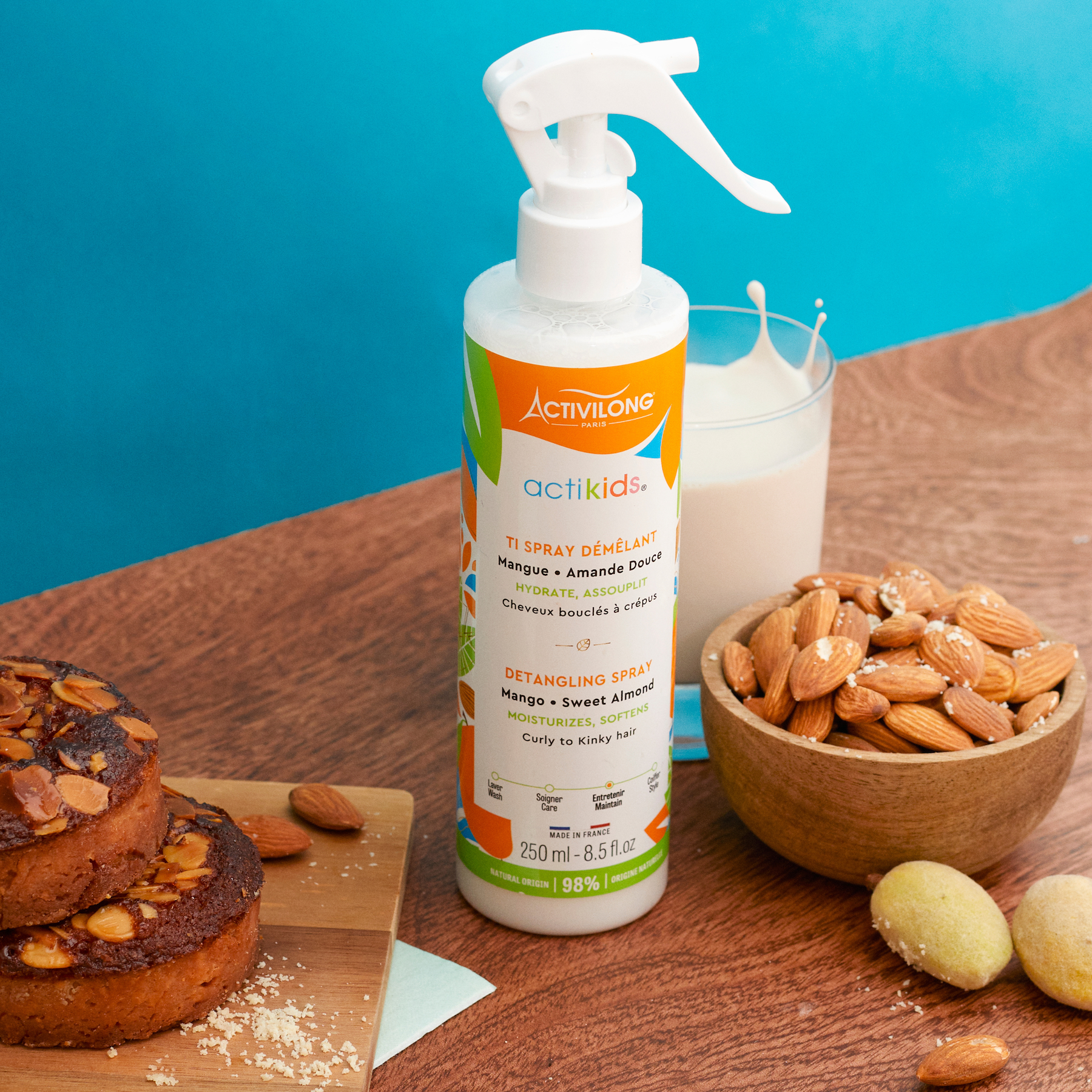 ACTIVILONG ACTIKIDS Ti Spray Démêlant 250ml bottle by Afro Beauty Store on a wooden table with almonds and a glass of milk.
