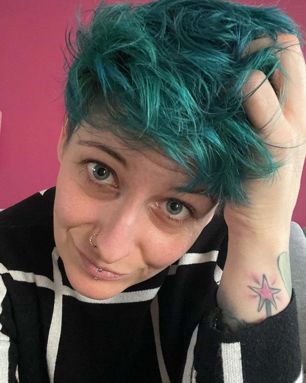 Crazy Colors' Person with teal hair against a pink background by Afro Beauty Store