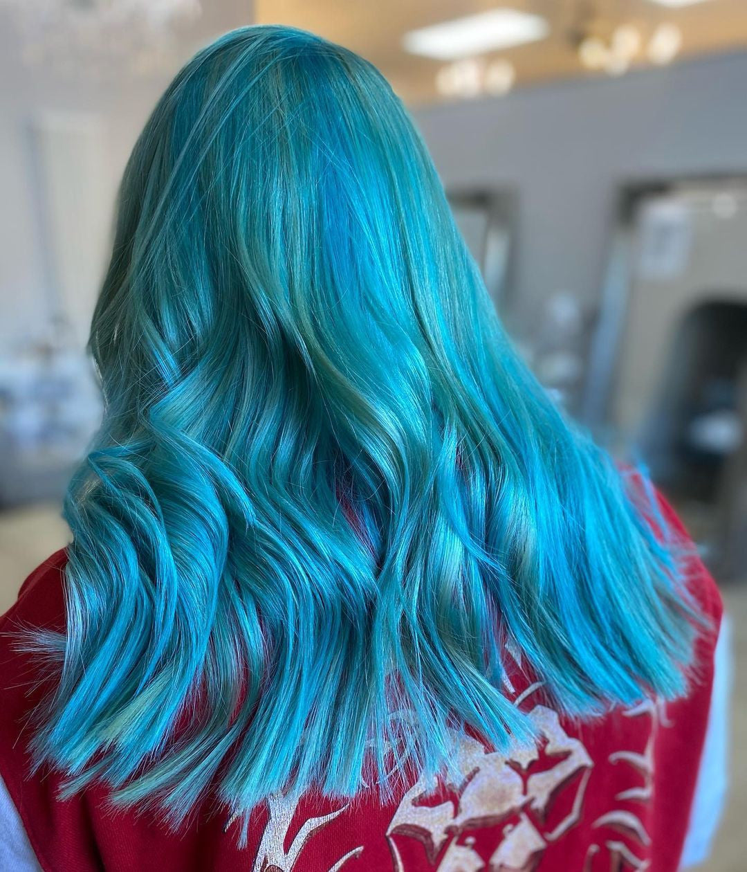 Crazy Color's Person with vibrant blue hair in a salon setting by Afro Beauty Store