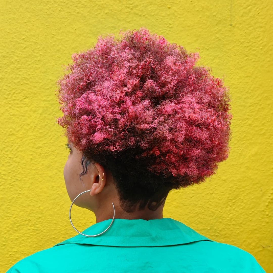 Crazy Color's Person with pink and black hair against a yellow wall by Afro Beauty Store