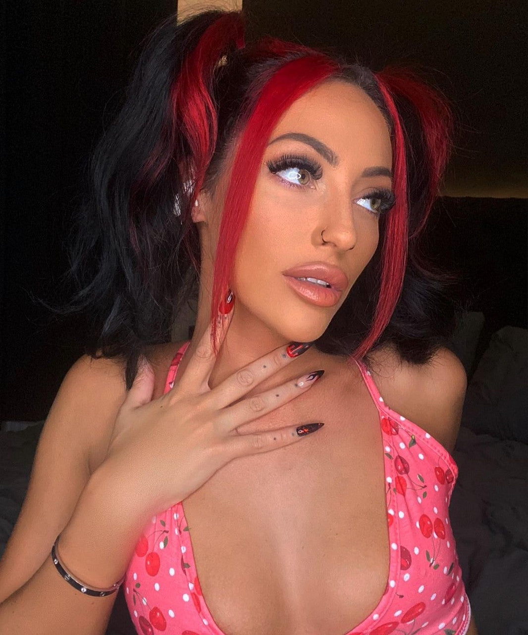 Crazy Color's person with red and black hair and nails and wearing pink bra by Afro Beauty Store
