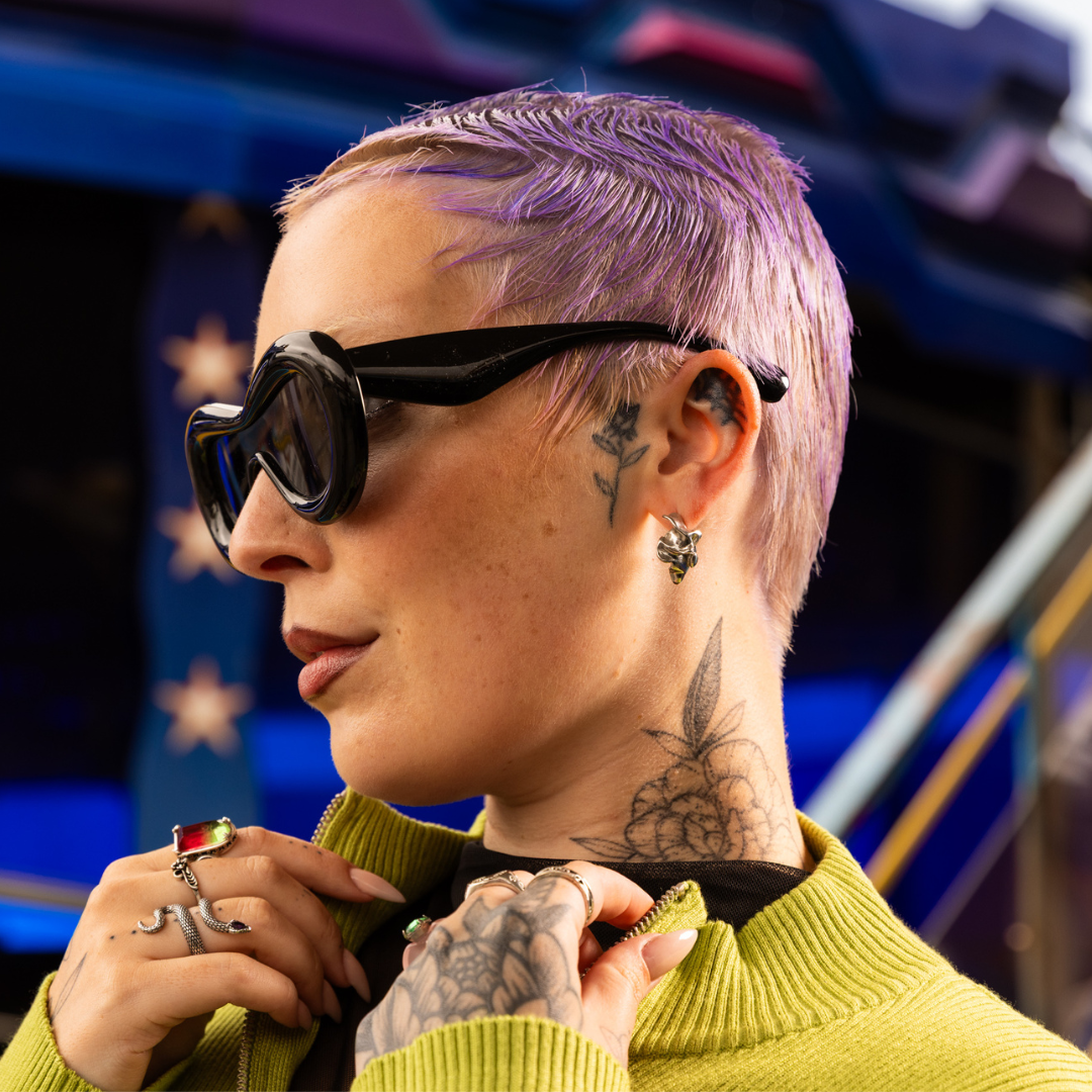 Crazy Color's Person with purple hair and tattoos wearing sunglasses and a green sweater by Afro Beauty Store