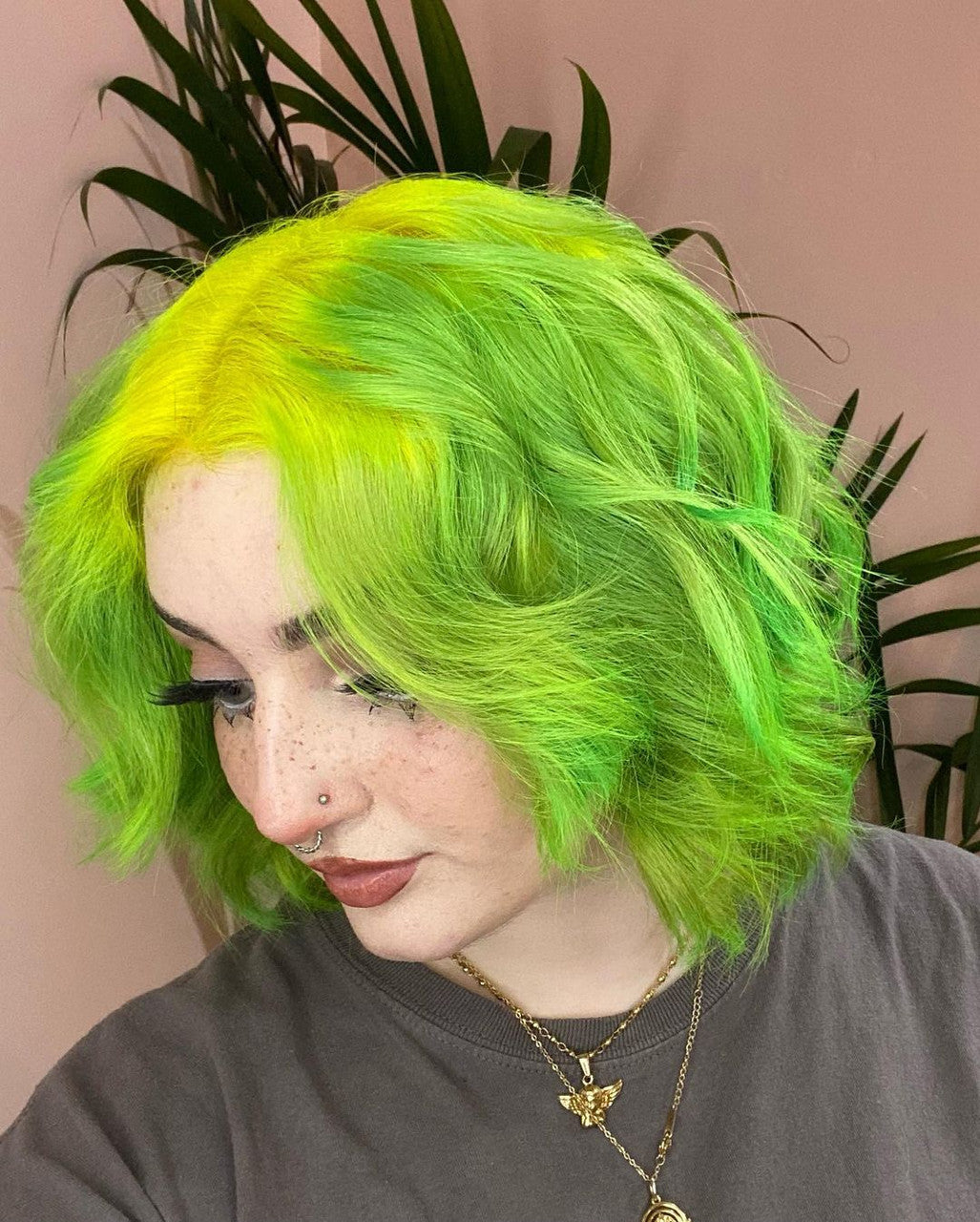 Crazy Color's Person with bright green hair against a pink background with plants by Afro Beauty Store