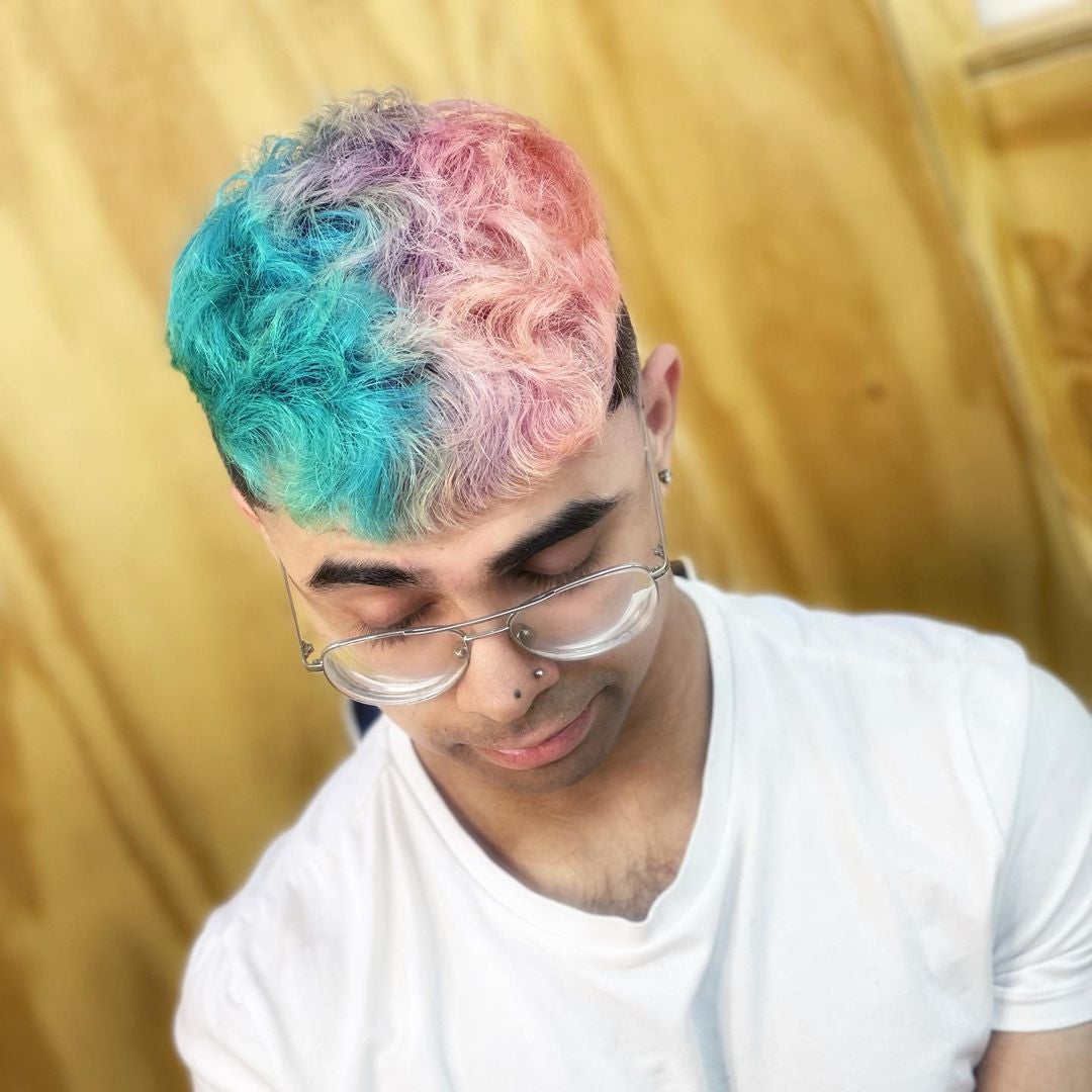 Crazy Color's Person with colorful hair and glasses against a gold background by Afro Beauty Store
