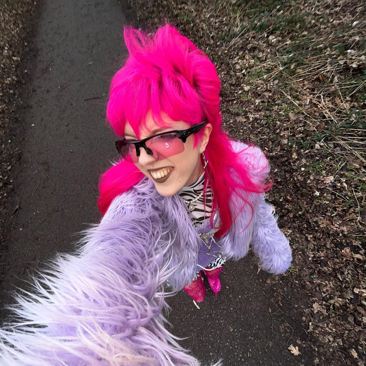Crazy Color's Person with bright pink hair and a purple jacket standing outdoors on a path by Afro Beauty Store