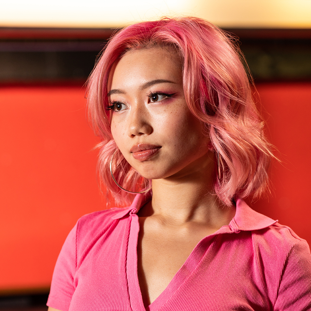 Crazy Color's person with pink hair & sweater by Afro Beauty Store