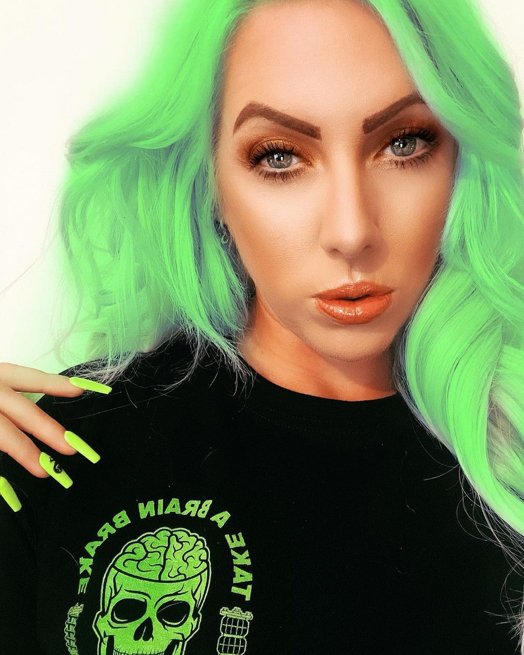 Crazy Color's Person with green hair and black shirt featuring a green graphic design by Afro Beauty Store