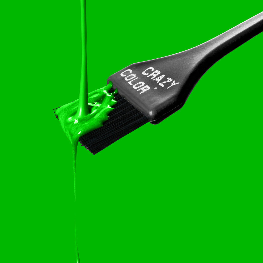 Crazy Color Toxic UV 79 hair dye liquid with Black hairbrush with 'Crazy Color' branding on a green background by Afro Beauty Store