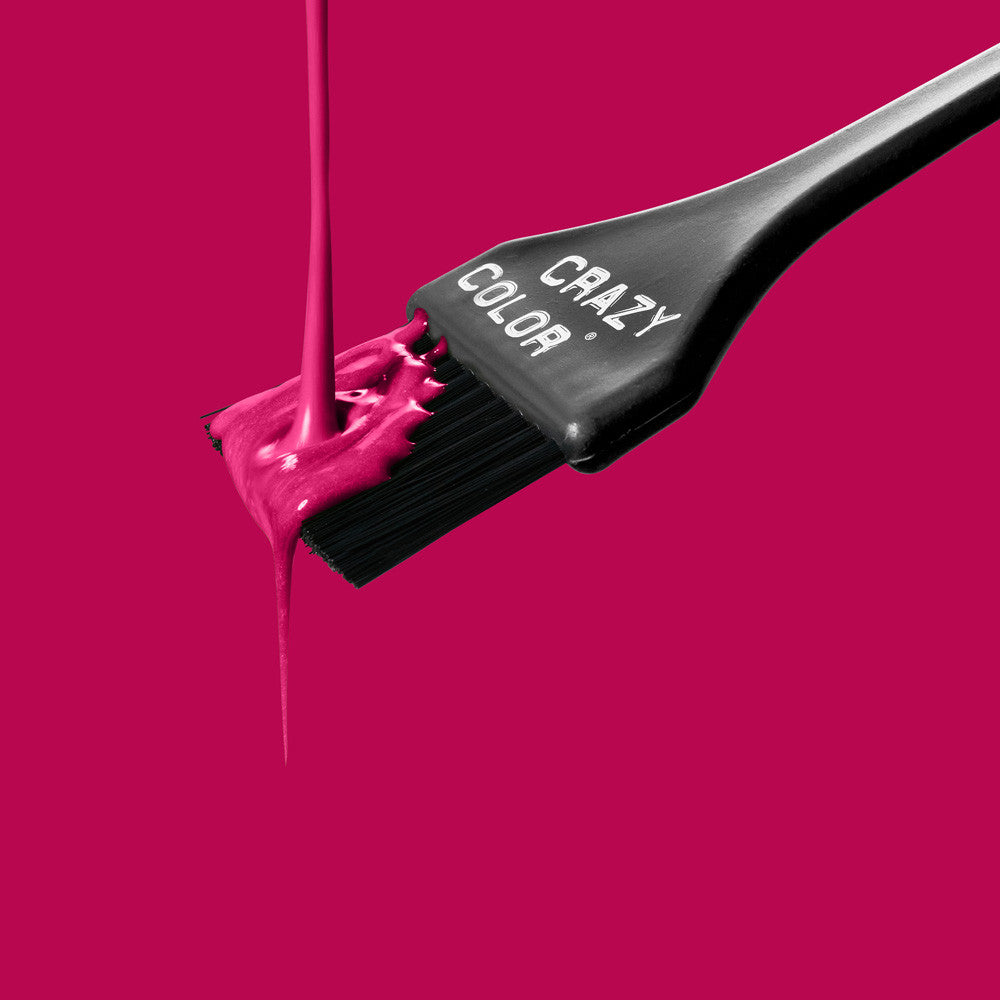 Black hair dye brush with Crazy Color's aubergine dye on a bright pink background by Afro Beauty Store