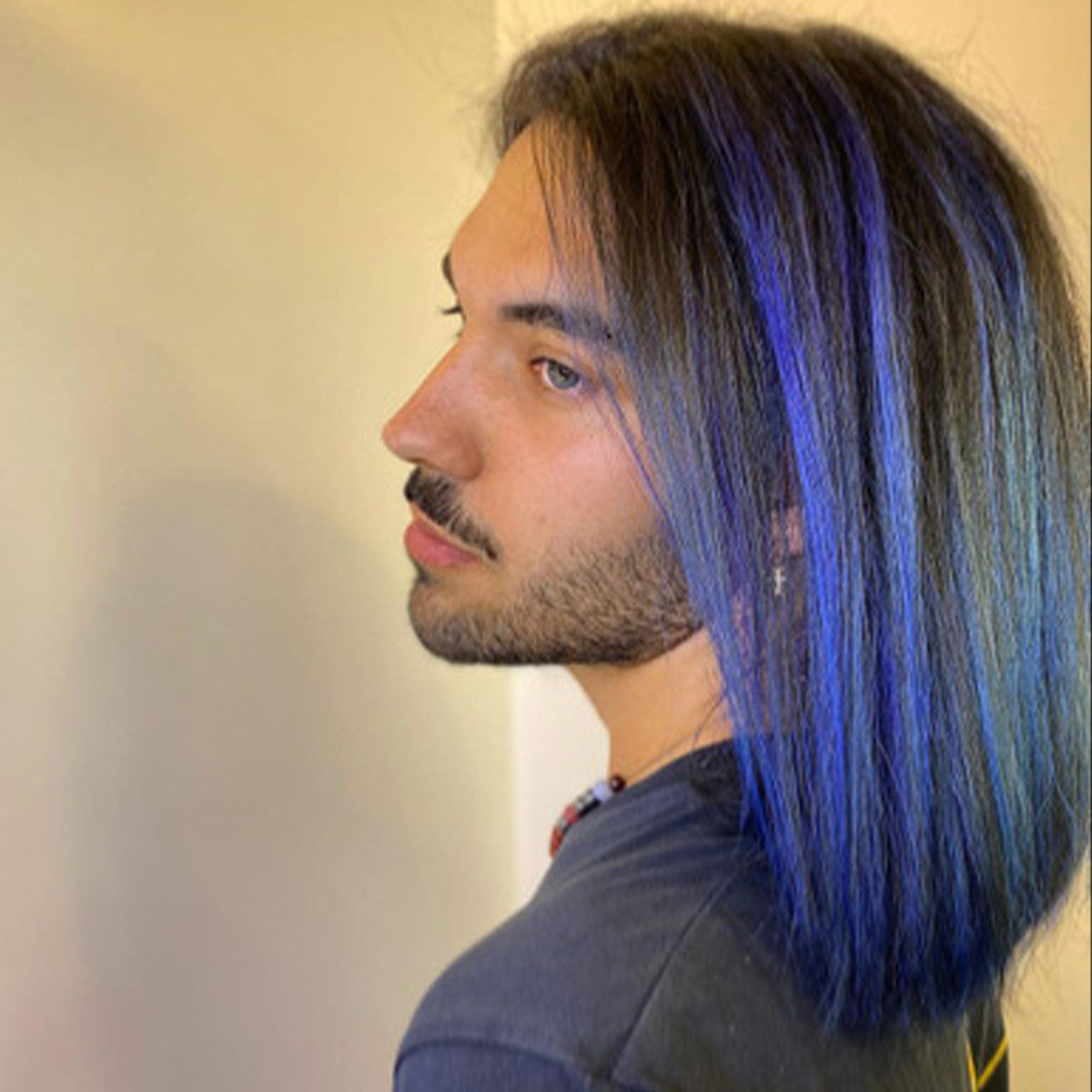Crazy Color's Person with blue hair and a beard, wearing a dark shirt, against a plain background by Afro Beauty Store