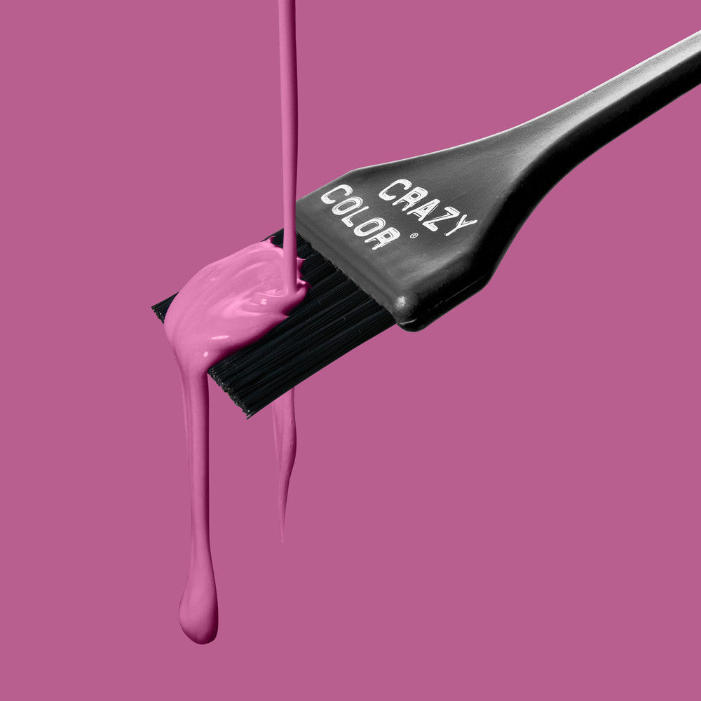 Crazy Color Hair dye brush with pink colorant dripping from it on a pink background by Afro Beauty Store