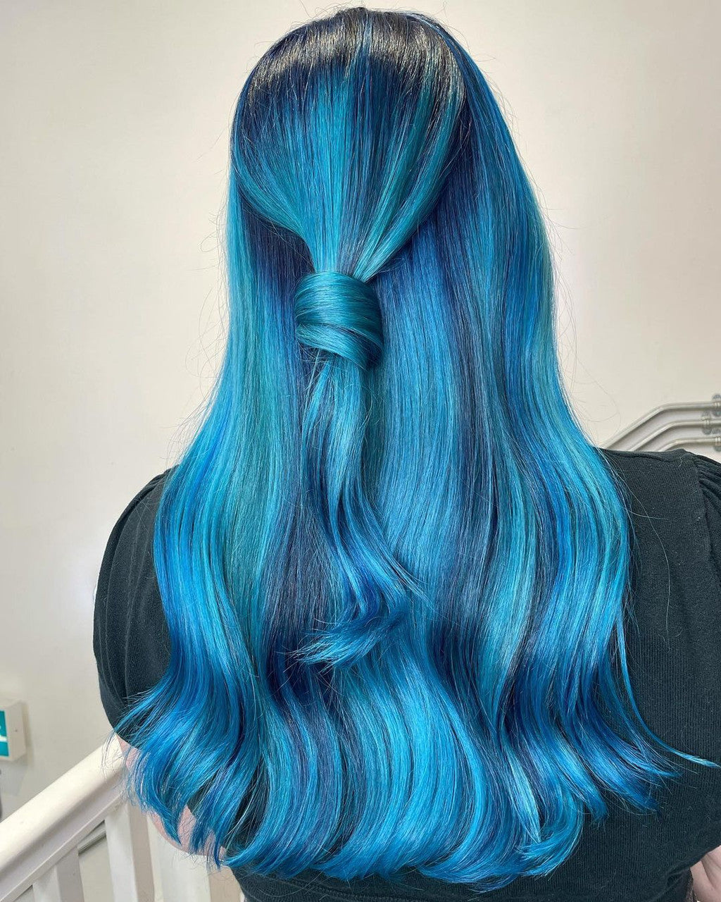 Crazy Color's Person with vibrant blue hair styled in a ponytail against a neutral background by Afro Beauty Store