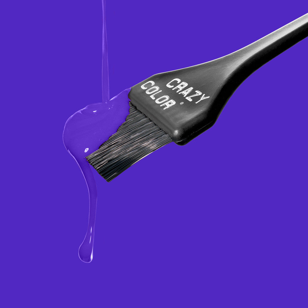 Crazy Color Hair dye brush with purple liquid dripping from it on a blue background by Afro Beauty Store