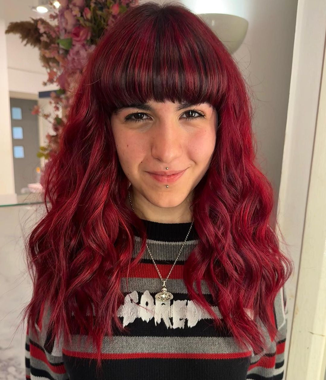 Person with vibrant red hair and a striped sweater indoors - Afro Beauty Store
