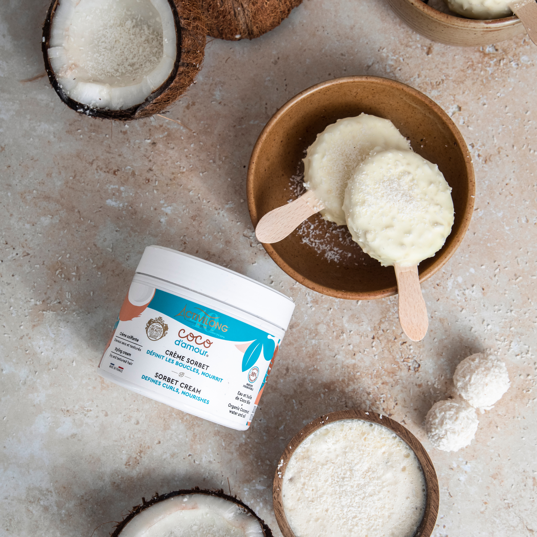 Coconut-based dessert cream with an ACTIVILONG COCO D’AMOUR Crème Sorbet 300ml Jar by Afro Beauty Store on a textured surface.