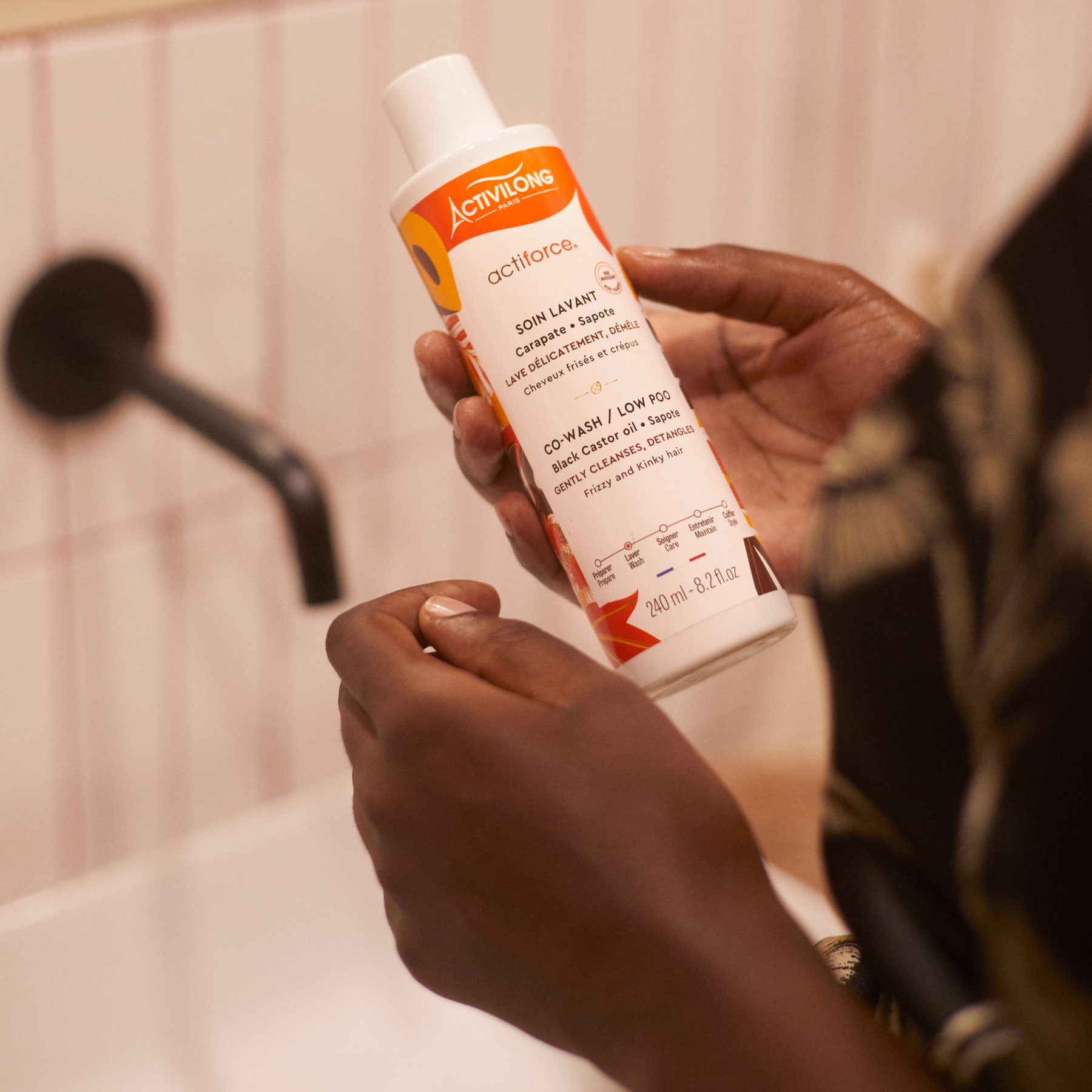 Person holding a Bottle of ACTIVILONG ACTIFORCE Co-wash 240ml by Afro Beauty Store in a bathroom setting