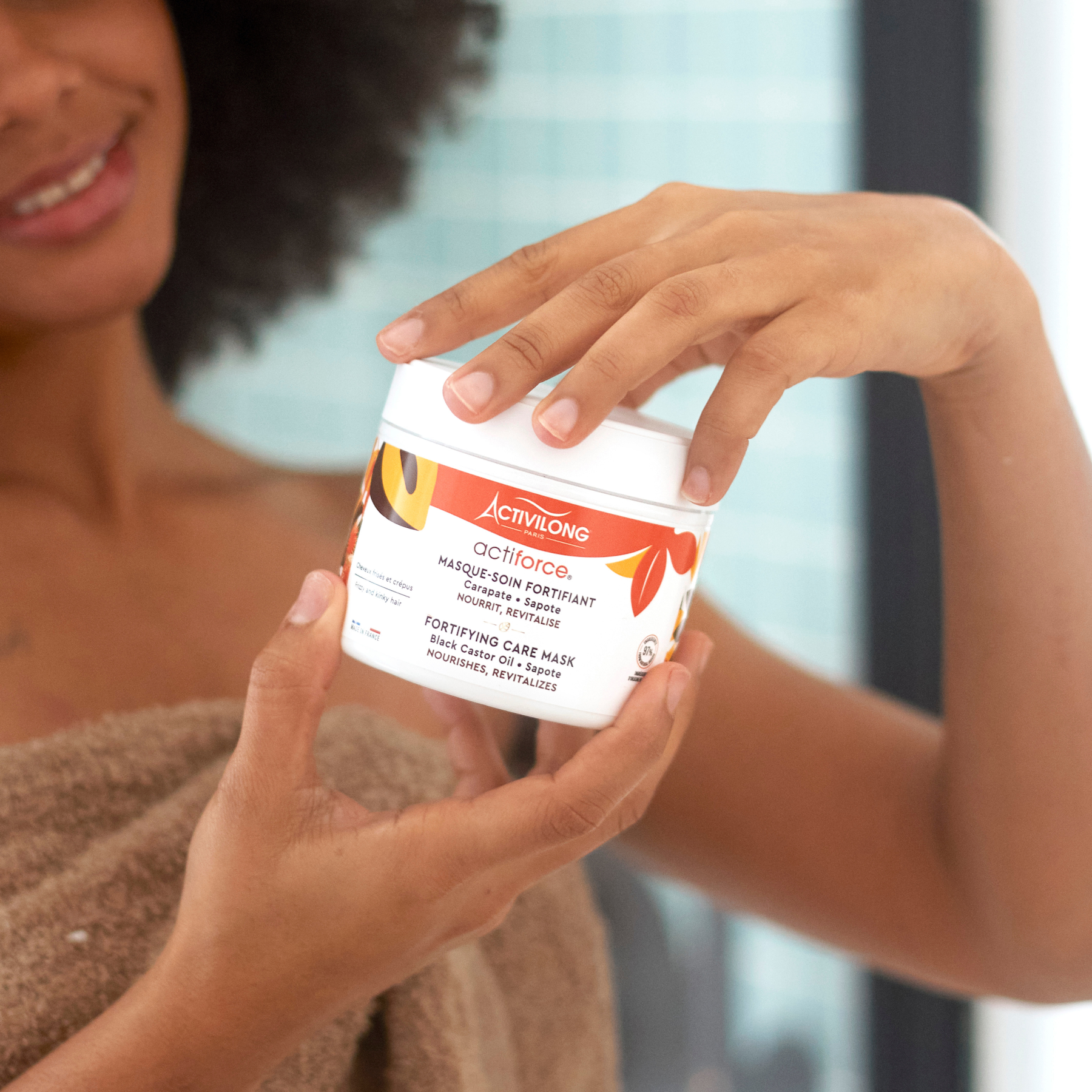 Person holding a ACTIVILONG ACTIFORCE Masque 300ml by Afro Beauty Store with a blurred background