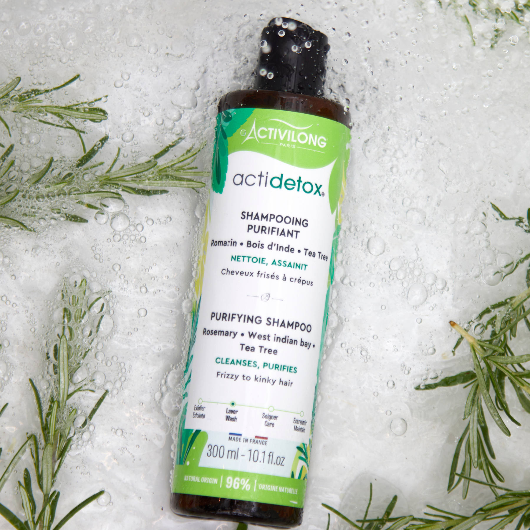 Activilong Actidetox Purifying shampoo bottle by Afro Beauty Store on a textured background with green leaves.